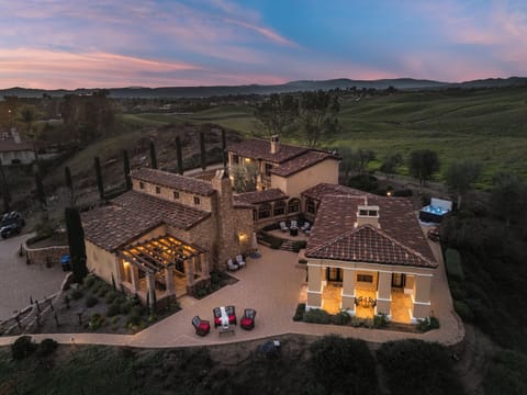 An illuminated estate set against rolling Temecula hills—where vineyard views and sunset skies set the tone for unforgettable evenings.