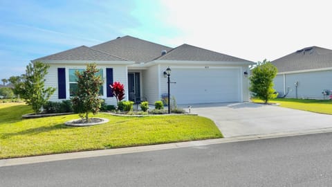 Charming single-story home with manicured landscaping and convenient driveway parking in a peaceful residential neighborhood.