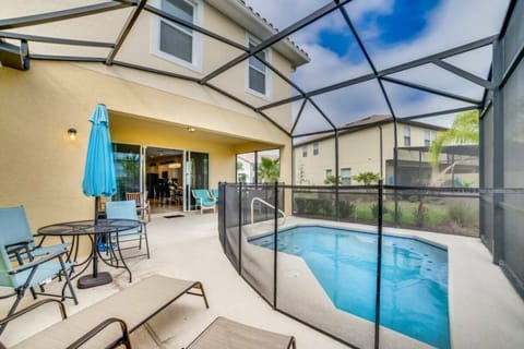 Step outside to discover a private oasis, featuring a sparkling pool surrounded by a secure screen enclosure. Relax in comfortable lounge chairs or gather around the sleek outdoor dining set, all under the inviting blue sky.