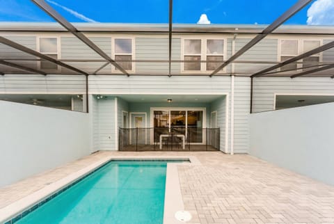 Step outside to your private oasis, featuring a sleek pool shimmering in the sun, surrounded by light pavers and modern walls. This spacious outdoor area flows effortlessly into the cozy living space, ideal for relaxation.