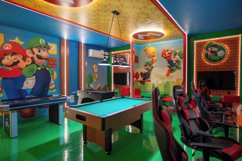 Welcome to a vibrant gaming paradise filled with bold colors and playful murals. Dive into friendly competition at the pool table or relax in sleek gaming chairs beneath a ceiling that sparkles with fun lighting.