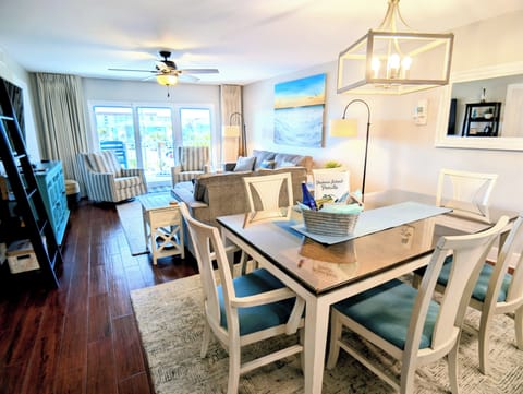 Bright coastal living room with dining space and private balcony access