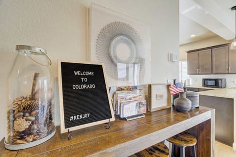 The entry transitions into an open-concept layout featuring a wooden console and thoughtful decor. This intentional design ensures a seamless flow between the main living areas and the fully stocked kitchen nearby.