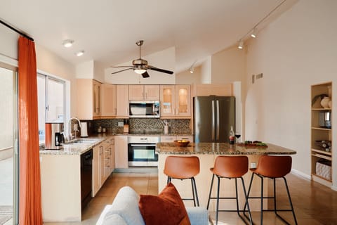 Fully equipped kitchen with stainless steal appliances and a kitchen island with bar seating for 3 guests.