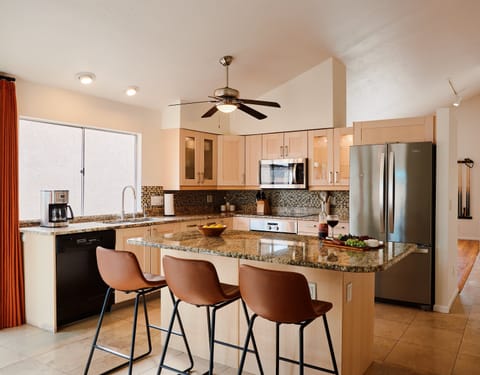 Fully equipped kitchen with stainless steal appliances and a kitchen island with bar seating for 3 guests.