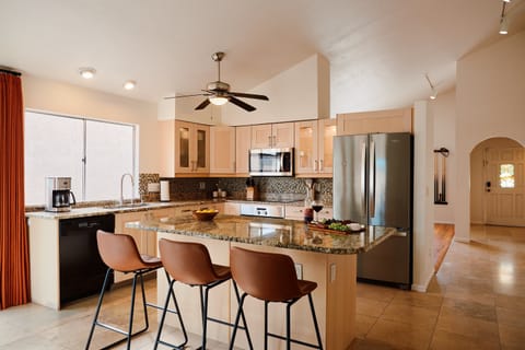 Fully equipped kitchen with stainless steal appliances and a kitchen island with bar seating for 3 guests.