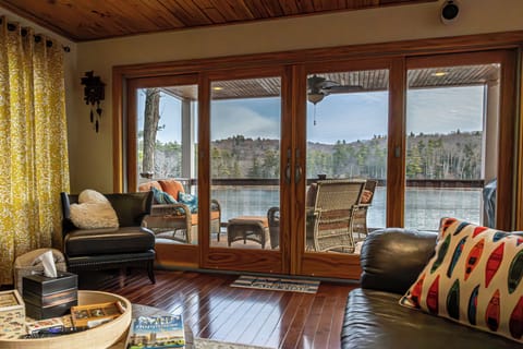 Lakeview living room with patio doors opening to private lake & outdoor seating