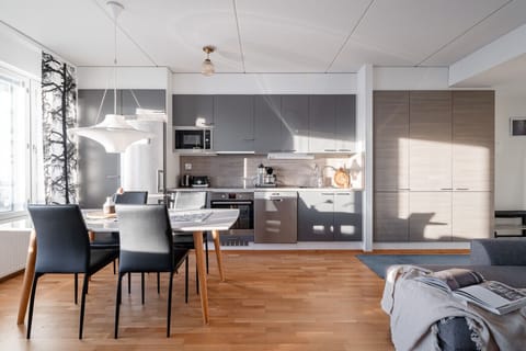 The open-plan living area combines a modern kitchen, dining space, and a cozy living room.