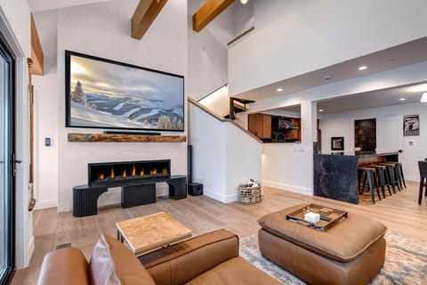 Relax in this stunning open-concept living space with soaring ceilings, exposed beams, and a cozy fireplace perfect for mountain evenings.
