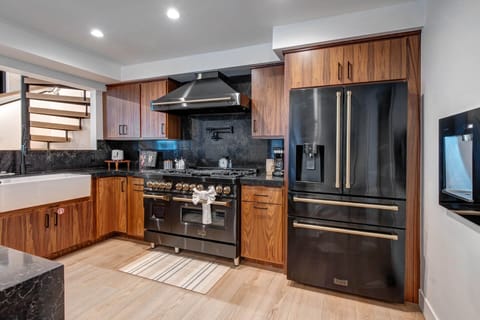 Cook your favorite meals in this sleek modern kitchen with premium stainless steel appliances, rich wood cabinetry, and elegant granite countertops.