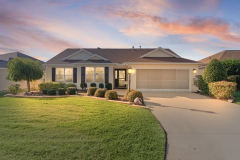 Elegant single-story home with manicured landscaping and spacious driveway, nestled in a peaceful residential neighborhood under dramatic evening skies.