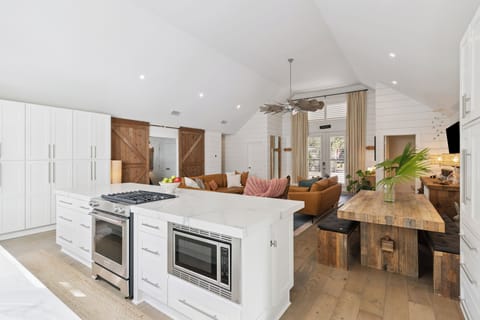 Your open-concept haven blends modern luxury with rustic charm, featuring a pristine white kitchen flowing into cozy living spaces.