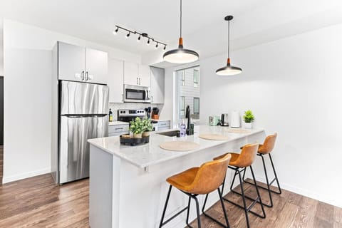 Bright Dining Area: Enjoy meals at the wooden dining table with seating for four, located right by the balcony for natural light.