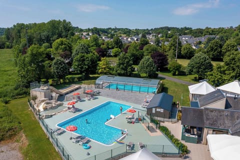 Dive into relaxation at Camping La Citadelle, where the sunlit pool beckons for a refreshing dip amidst lush greenery.