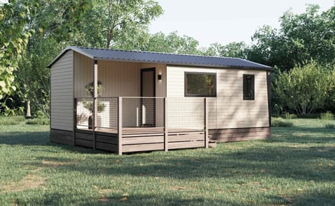 Nestled in a tranquil setting, the exterior of the Mobil-home features a charming wooden deck and a welcoming facade, perfect for relaxing in the fresh air.