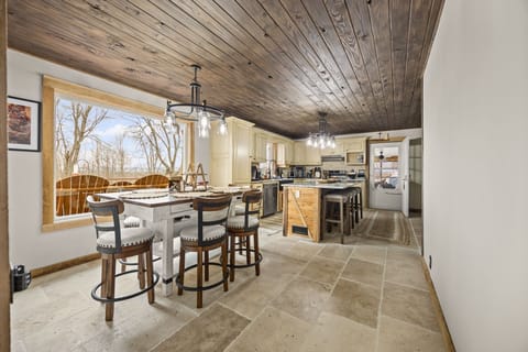 Gather around the rustic dining table while the open kitchen invites home-cooked meals and shared memories.