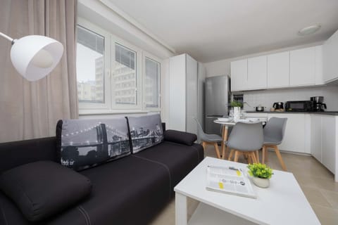 Bright living room with sofa and open kitchen.