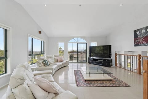 Unwind upstairs in the second living area, where plush seating, a large TV, and open views create the perfect setting for cosy movie nights.