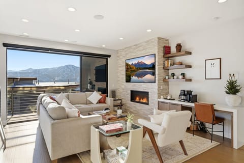 Bright living room with fireplace and mountain views