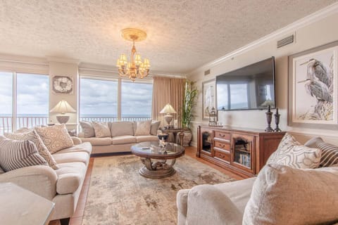 Open concept living area with comfortable furnishings and a HUGE TV for premier movie watching