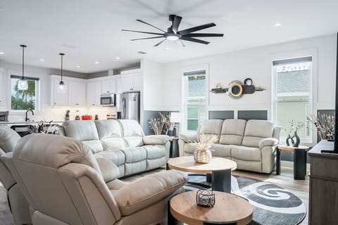 Comfy living room with ample seating and large smart TV faux fire place