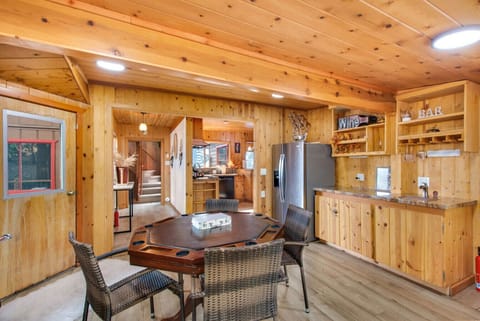Open game space with poker table flowing into the kitchen area.