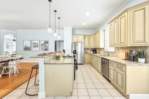 Completely stocked chef's kitchen with granite counters, stainless appliances, and seamless flow into dining