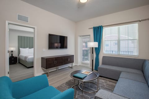 Unwind in your stylish living space with modern furnishings and vibrant turquoise accents creating the perfect atmosphere for relaxation.
