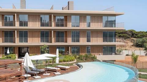 Modern luxury meets the Algarve sun. Enjoy the infinity pool and elegant architecture steps from the beach. #Quarteira #AlgarveLuxury #LovelyStay #PoolView #DesignCondo