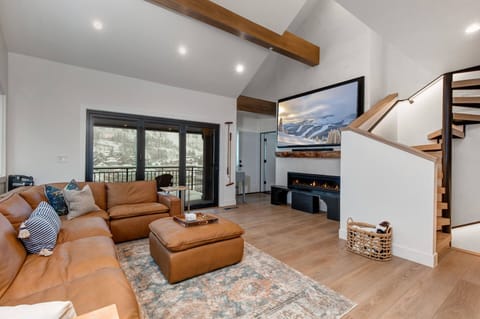 Settle into plush leather seating by the glowing fireplace. Vaulted ceilings and mountain views through expansive windows create your perfect retreat. Cozy textures and modern warmth welcome you home.
