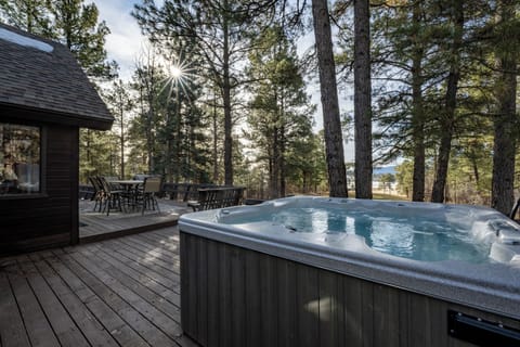 Soak your worries away in your private hot tub surrounded by towering pines, while golden sunlight filters through the forest canopy above.