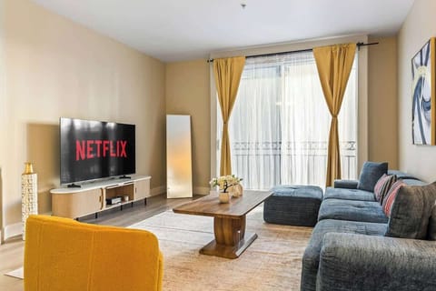 Spacious living room with a large sectional sofa, smart TV, and open layout. Ideal for relaxing, socializing, and enjoying your stay.