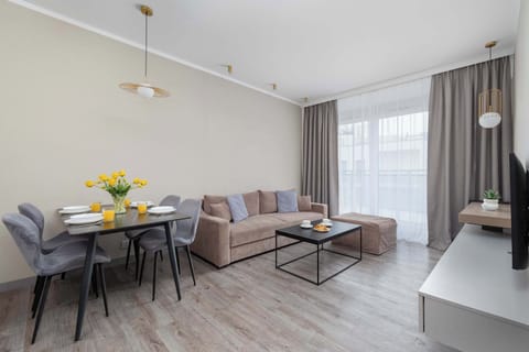 A wide view of the living room and dining area with stylish furniture and soft lighting. The space feels modern and airy.