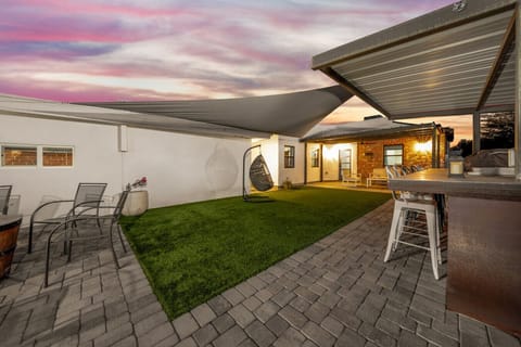Fenced backyard with turf lawn, outdoor seating, gas grill, fire pit, and hot tub — ideal outdoor living space (NOTE: Backyard and hot tub are SHARED with guests in the house in front of the Casita.)