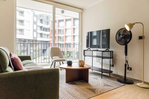 Bright and modern living room with a cozy sofa and large window overlooking the cityscape.