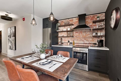 A warm, inviting space featuring a dining table crafted from restored wood reclaimed from the building’s original 1800s structure.