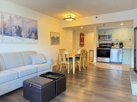 Entertainment-ready living area with TV, opening to the dining space.