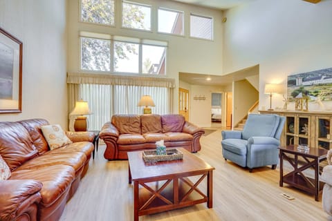 Spacious living room with vaulted ceilings, large windows, and comfortable seating