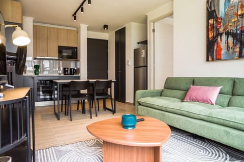 Stylish living area with modern kitchen and vibrant artwork, perfect for relaxation and dining.
