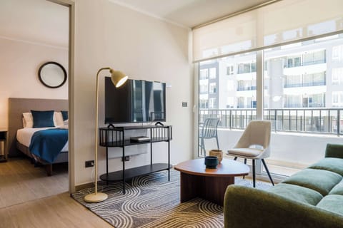 Bright and cozy living area with modern furnishings and a balcony view, perfect for relaxation.