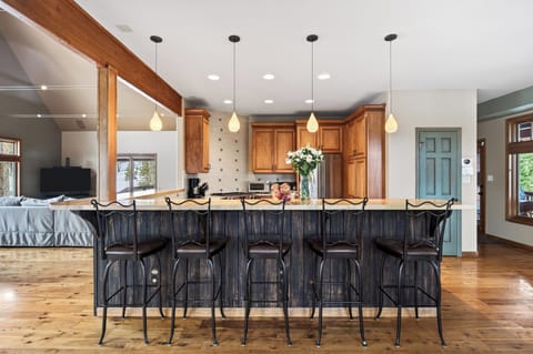 The kitchen features a large island with barstool seating and modern appliances.