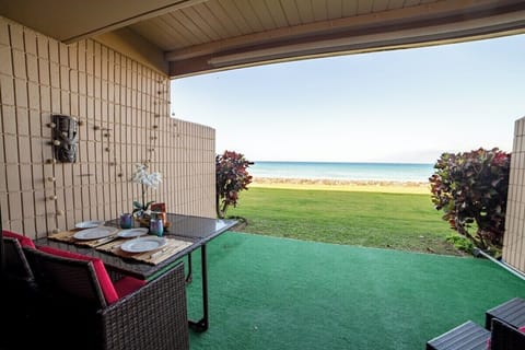 Private lanai overlooking lush lawn and sparkling sea