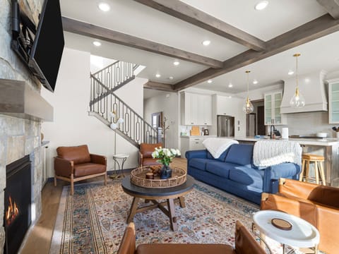 Primary living room at Summit View Lodge with large cozy gas fireplace, large smart TV, ample luxurious seating and a large amazing deck with unobstructed views of Mount Timpanogos