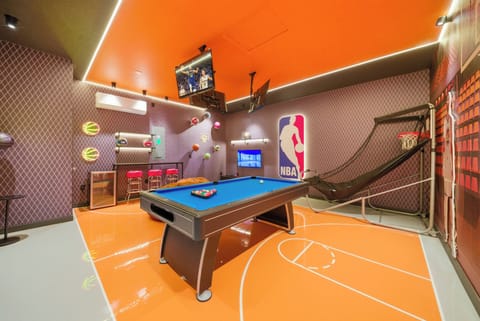 Welcome to our lively game room, where fun meets relaxation! Enjoy friendly competition at the stylish pool table, relax in sleek seating, and catch the action on a large screen, all surrounded by vibrant NBA memorabilia.