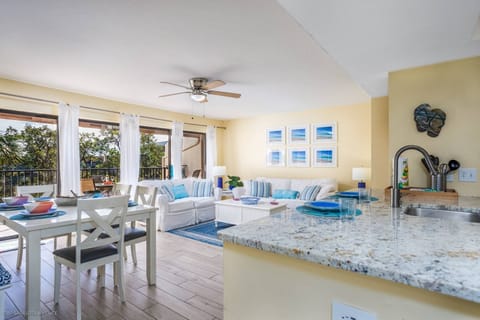 Your bright, open living space flows seamlessly from granite kitchen to comfortable seating area with balcony access.