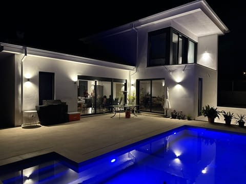 Our villa by night, pool lights on every night during your stay, off at midnight