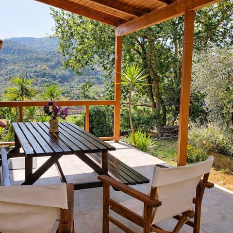 Spacious covered terrace furnished with a wooden table and seating to enjoy the scenery.