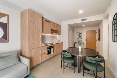 Modern kitchen and dining nook with warm wood cabinetry