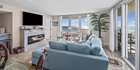A bright, modern living room bathed in natural light, with floor-to-ceiling windows stretching across two adjoining wall