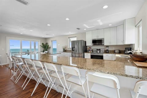 Oceanfront kitchen with island seating and panoramic beach views. 🌊🍽️